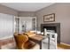 Office space with a fireplace, wooden desk and comfortable chairs for working, and featuring glass paneled french doors at 7411 S Crescent Ct, Littleton, CO 80120