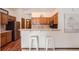 Efficient kitchen with breakfast bar, wooden cabinetry, and view into adjacent living spaces at 2288 S Depew St, Lakewood, CO 80227