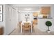 Dining area with a modern white table set, tiled floors, and closet doors at 3335 S Ammons St # 6-102, Lakewood, CO 80227