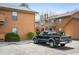 Exterior view of property featuring parked truck and wood paneled apartments at 3335 S Ammons St # 6-102, Lakewood, CO 80227