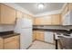 Bright kitchen with white appliances, wooden cabinets, tile floor, and dark countertops at 3335 S Ammons St # 6-102, Lakewood, CO 80227