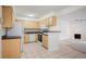 Bright kitchen with white appliances, wood cabinets and tile flooring next to living room at 3335 S Ammons St # 6-102, Lakewood, CO 80227