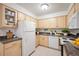 Updated kitchen featuring wooden cabinets, white appliances, and tile flooring at 3335 S Ammons St # 6-102, Lakewood, CO 80227