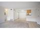 Spacious living room with white walls, carpet, and tile, leading into the kitchen area at 3335 S Ammons St # 6-102, Lakewood, CO 80227
