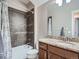 Charming bathroom featuring a vanity with granite countertop, classic fixtures, and a shower-tub combo with tiled walls at 5590 W 97Th Ave, Westminster, CO 80020
