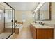 Bathroom with a soaking tub, glass-enclosed shower, and double sink vanity with granite counters at 12996 Banyon Cir, Parker, CO 80134
