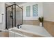 A soaking tub is next to a glass shower in this updated bathroom at 12996 Banyon Cir, Parker, CO 80134