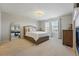Spacious bedroom featuring a cozy fireplace, large mirror, and bright natural light at 12996 Banyon Cir, Parker, CO 80134