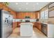 Well-lit kitchen featuring stainless steel appliances, granite countertops, and a stylish white kitchen island at 12996 Banyon Cir, Parker, CO 80134