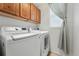 Efficient laundry room featuring a modern washer and dryer set, ample cabinet space, and a window at 12996 Banyon Cir, Parker, CO 80134