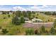 Beautiful aerial view of home with large garage, mature trees, and white fencing at 3672 Deer Creek Dr, Parker, CO 80138