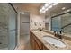 Double vanity bathroom with stone countertops, tile shower, and open closet at 3672 Deer Creek Dr, Parker, CO 80138