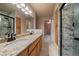 Bathroom featuring double granite vanity sinks, walk-in shower and access to walk-in closet at 3672 Deer Creek Dr, Parker, CO 80138