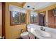Bathroom with large windows, a granite countertop and wood stained cabinets at 9 Red Fox Ln, Littleton, CO 80127