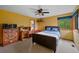 Bedroom with a wooden dresser, desk, bed, and large window for natural light at 9 Red Fox Ln, Littleton, CO 80127