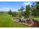 Outdoor fire pit and seating area surrounded by lush landscaping and mature trees at 9 Red Fox Ln, Littleton, CO 80127
