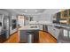 Modern kitchen features stainless steel appliances, white cabinetry, and a large center island at 9 Red Fox Ln, Littleton, CO 80127