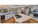 Kitchen island with stovetop, quartz countertops, white cabinets, and stainless appliances at 9 Red Fox Ln, Littleton, CO 80127