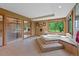 The main bathroom features a tub, shower, and windows overlooking the property's outdoor greenery at 9 Red Fox Ln, Littleton, CO 80127