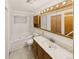 Bathroom with tub/shower combination and cabinet with sink and large mirror at 10951 Rosalie Dr, Northglenn, CO 80233
