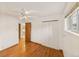 Bedroom with hardwood floors, closet, ceiling fan and a window allowing natural light at 10951 Rosalie Dr, Northglenn, CO 80233