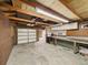 Spacious garage interior with exposed beams, workbench, and ample storage space at 10951 Rosalie Dr, Northglenn, CO 80233