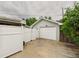 Detached garage with a white garage door, surrounded by a fenced in yard, and greenery at 10951 Rosalie Dr, Northglenn, CO 80233