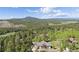 Aerial view of a charming home nestled among trees in a picturesque setting with mountain views at 11033 Barker Ave, Conifer, CO 80433