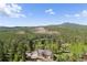 An aerial view of a home nestled in lush forest at 11033 Barker Ave, Conifer, CO 80433