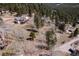 Aerial view of a house with a large deck surrounded by lush forest at 11033 Barker Ave, Conifer, CO 80433