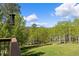 Scenic backyard view from the deck, showcasing a lush green lawn and a charming wooded area at 11033 Barker Ave, Conifer, CO 80433
