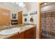 Bathroom features double sinks, granite countertops, wood cabinets, and a shower with decorative curtain at 11033 Barker Ave, Conifer, CO 80433