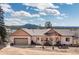 Charming single-Gathering home featuring an attached two-car garage and a welcoming front porch, set against a mountain backdrop at 11033 Barker Ave, Conifer, CO 80433