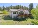 Back view of the home featuring a large deck, steps, and spacious yard at 11033 Barker Ave, Conifer, CO 80433