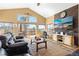 Open living room with wood floors, access to outdoor patio, and comfortable leather seating at 11033 Barker Ave, Conifer, CO 80433