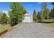 Single-car garage with gravel driveway and surrounding greenery at 11033 Barker Ave, Conifer, CO 80433