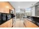 Modern kitchen with light wood cabinets, black backsplash, stainless steel appliances and exterior balcony access at 1700 Bassett St # 703, Denver, CO 80202