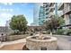 Stone fire pit on outdoor patio with greenery and views of the modern high-rise building at 1700 Bassett St # 703, Denver, CO 80202
