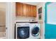 Dedicated laundry room with modern washer and dryer, ample storage, and a bright blue door at 1748 Atwood St, Longmont, CO 80501