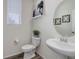 Stylish half bathroom featuring a pedestal sink, modern fixtures, and contemporary decor at 1246 Blackhaw St, Elizabeth, CO 80107