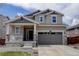 Charming two-story home with a covered porch, stone accents, and a two-car garage on a sunny day at 1246 Blackhaw St, Elizabeth, CO 80107