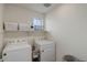 Bright laundry room with modern white appliances and ample shelving space for storage at 1246 Blackhaw St, Elizabeth, CO 80107