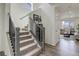 Carpeted staircase with modern railing and adjacent hallway leading to a living room, showcasing the home's interior at 1246 Blackhaw St, Elizabeth, CO 80107