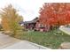 Red bungalow with fall foliage and a landscaped yard at 103 S Park Ave, Fort Lupton, CO 80621