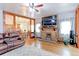 Living room features a stone fireplace, hardwood floors, and a view to the kitchen at 103 S Park Ave, Fort Lupton, CO 80621