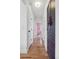 Hallway with wood floors and built in storage leads to a pink room with a large window at 4419 W 34Th Ave, Denver, CO 80212