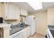 Kitchen features granite countertops, white cabinets and a dishwasher at 4400 S Quebec St # 204N, Denver, CO 80237