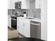 Modern kitchen features sleek appliances, white cabinetry, and contemporary gray backsplash at 2851 W 52Nd Ave # 304, Denver, CO 80221