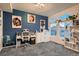 Bright home office with white desk, gray carpet, and blue accent wall featuring art at 4526 N Quatar Ct, Aurora, CO 80019