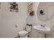 Cozy powder room featuring a vessel sink, round mirror, and decorative wall shelves at 4526 N Quatar Ct, Aurora, CO 80019